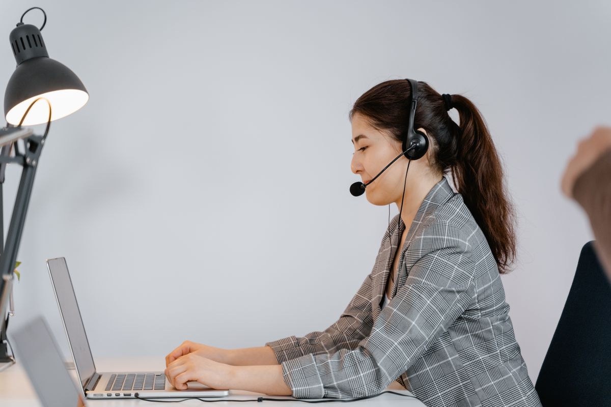 Virtual assistant working at a laptop with a headset